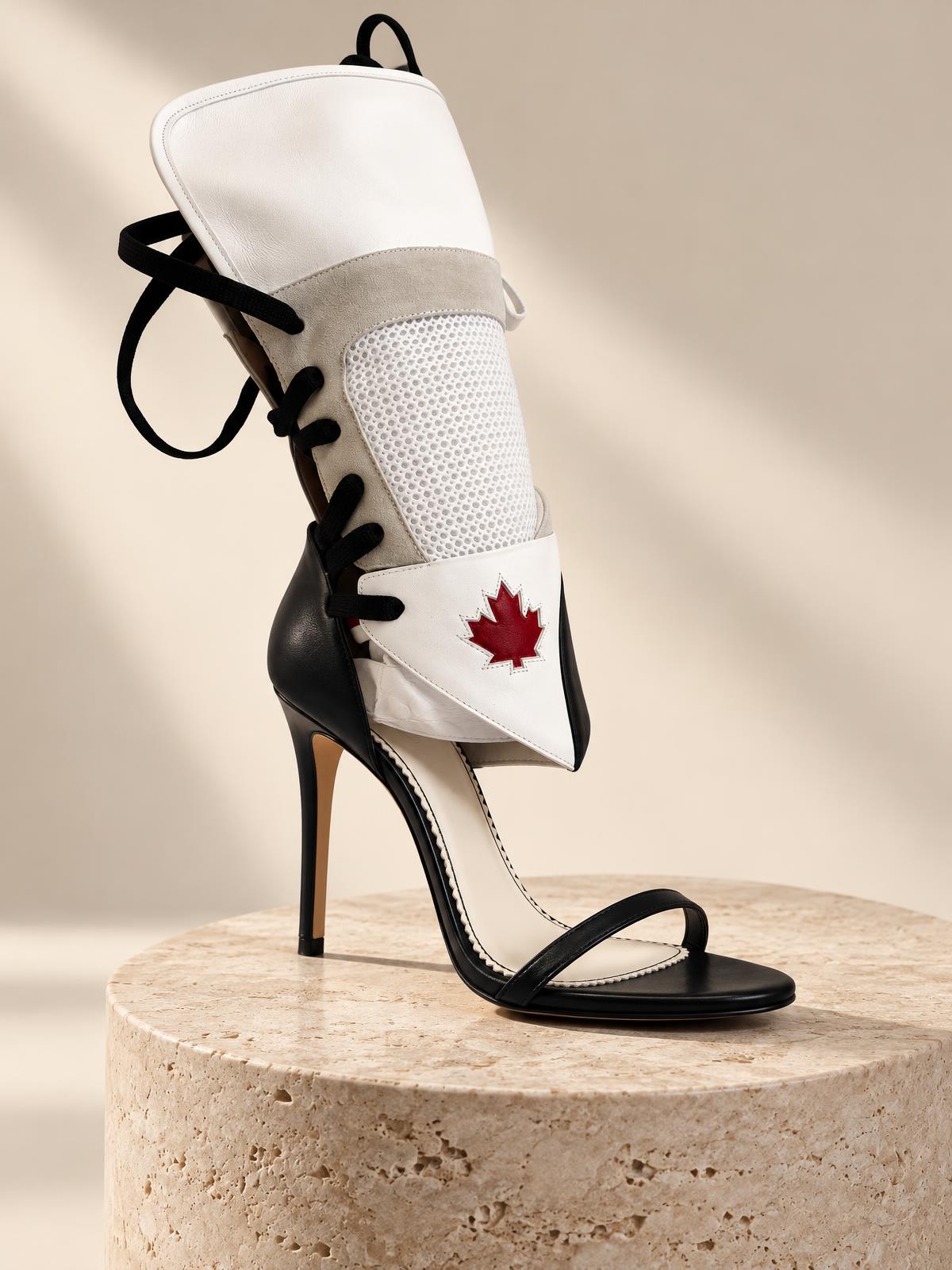 White DSQUARED2 leather and mesh stiletto with red maple leaf on a travertine plinth